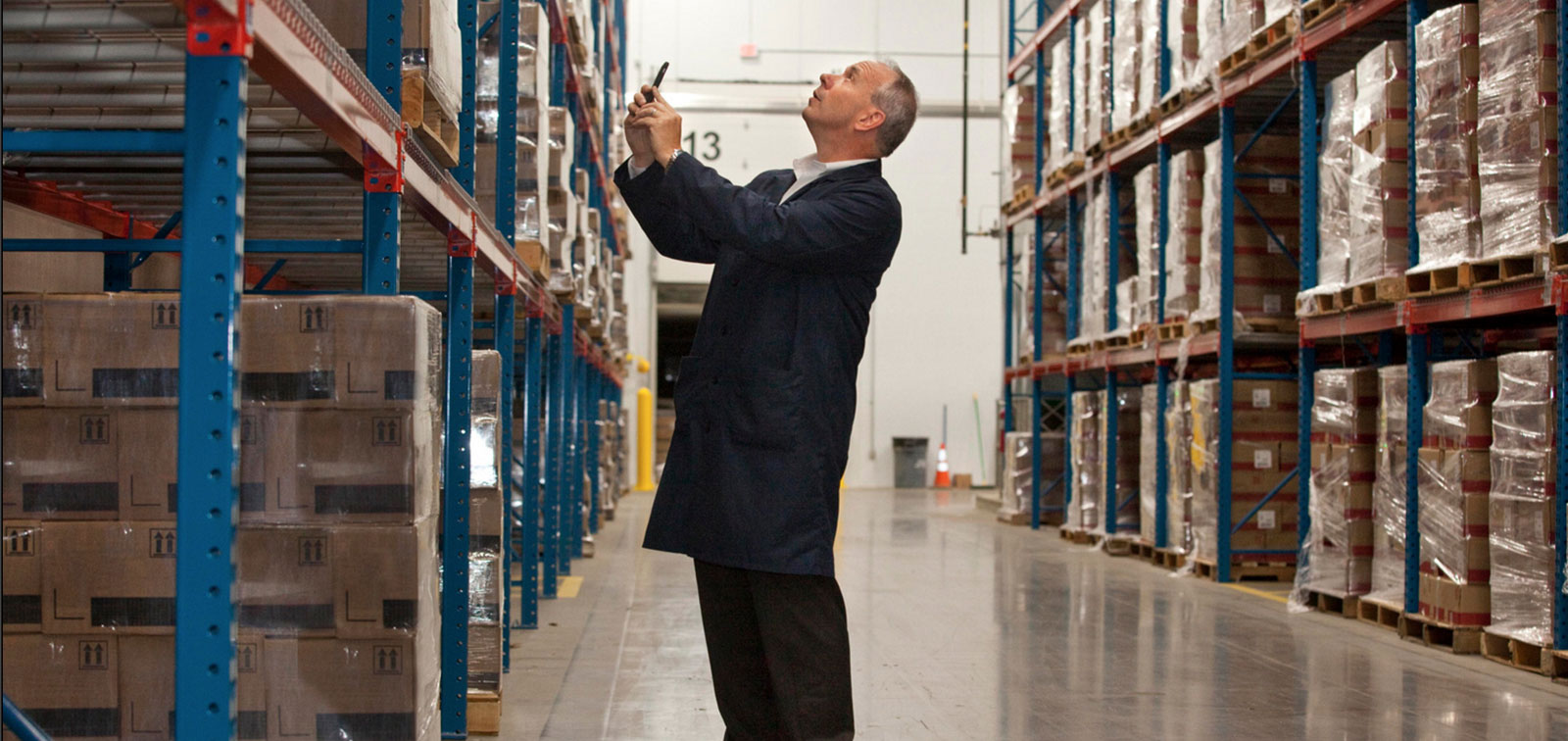 Business man taking picture in a warehouse